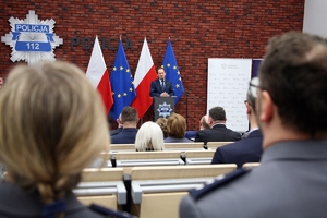 uczestnicy konferencji słuchają przemówienia prelegenta stojącego przy mównicy