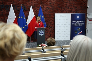 uczestnicy konferencji słuchają przemówienia prelegentki stojącej przy mównicy