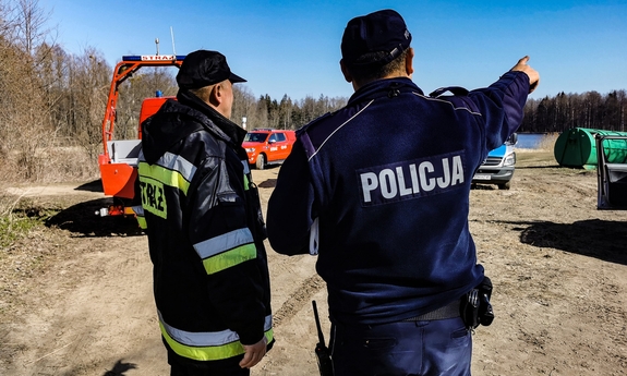 policjant i strażak podczas poszukiwań w terenie