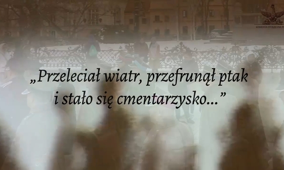 kadr z filmu, napis &quot;Przeleciał wiatr, przefrunął ptak i stało się cmentarzysko...&quot;, w tle zarys idących ludzi