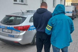 policjant z zatrzymanym przy radiowozie