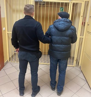 policjant z zatrzymanym mężczyzną