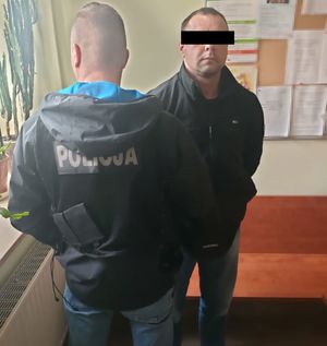 policjant z zatrzymanym mężczyzną