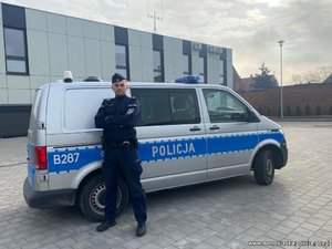 umundurowany policjant stojący obok radiowozu