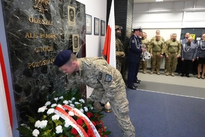 funkcjonariusz BOA składa wieniec kwiatów przed tablicą