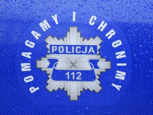 Policyjna gwiazda z napisem Pomagamy i chronimy na policyjnym radiowozie