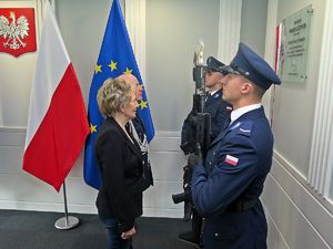 Komendant Główny Policji i kobieta z rodziny zmarłej Marii Czernek przed tablicą jej imienia