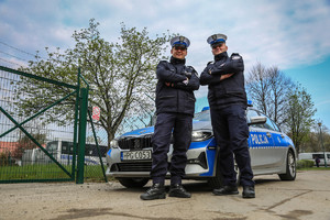 Policjanci, którzy eskortowali rodzącą kobietę pozują do zdjęcia przy radiowozie