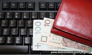 pieniądze i portfel leżące na klawiaturze komputera