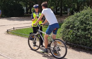 policjantka wręcza ulotkę rowerzyście