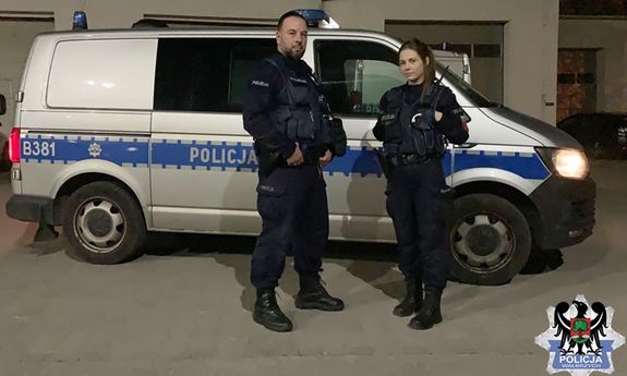 umundurowany patrol policji stoi obok radiowozu