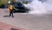Mężczyzna z gaśnica i dym unoszący się spod maski auta