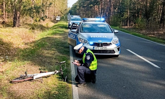 Policjant wykonuje oględziny w miejscu wypadku drogowego