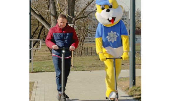 mężczyzna i policyjna maskotka jadą hulajnogami