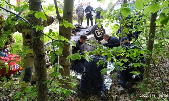 Miejsce zdarzenia drogowego w Kolbuszowej Dolnej. Na zdjęciu policjanci udzielający pomocy poszkodowanej kobiecie