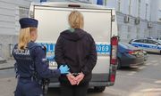 umundurowana policjantka prowadzi zatrzymaną kobietę