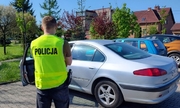 policjant stojący przed kradzionym autem