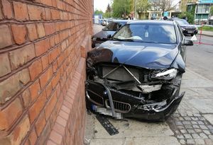 czarny samochód marki bmw z rozbitym przodem