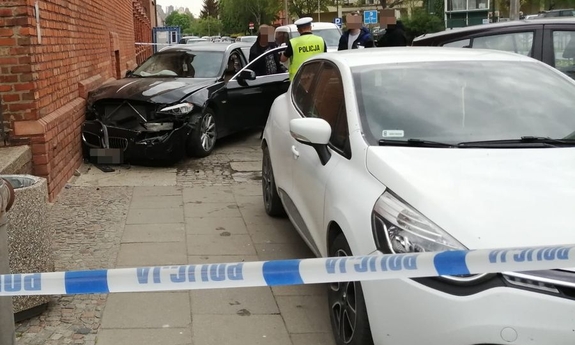 miejsce kolizji drogowej, na pierwszym planie biały samochód w tle czarne bmw, którym poruszał się nietrzeźwy kierowca