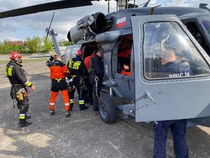 strażacy i policjanci przy policyjnym śmigłowcu