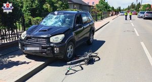 Rozbity samochód na chodniku z widocznymi uszkodzeniami po potrąceniu rowerzystki