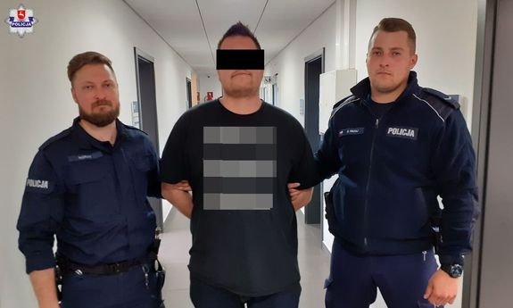 dwaj policjanci prowadzą zatrzymanego