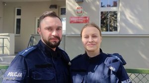 dwoje policjantów pozuje do zdjęcia, w tle widać budynek Komisariatu Policji w Gdańsku