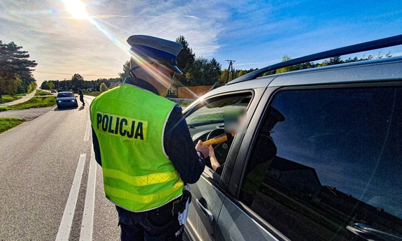 Policjant bada stan trzeźwości kierowcy