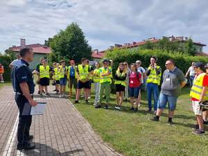 uczestnicy turnieju, grupa młodzieży stoi naprzeciwko policjanta