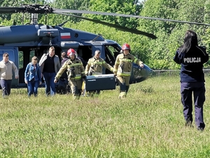 Słoneczny dzień. Na polowym lotnisku śmigłowców z pokładu policyjnego Black Hawka trzej strażacy w asyście kilku cywili przenoszą transporter z organem do transplantacji. Naprzeciw strażaków wychodzi policjantka w mundurze.