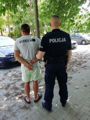 policjant prowadzi zatrzymanego