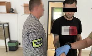 policjant prowadzi zatrzymanego