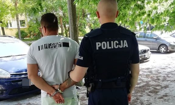 policjant prowadzi zatrzymanego