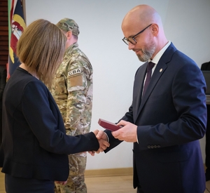 uczestnicy uroczystości, mężczyzna wręcza kobiecie medal