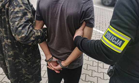 dwaj policjanci z zatrzymanym mężczyzną