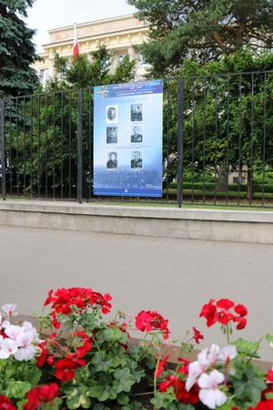 widok na budynek Komendy Głównej Policji, na płocie wisi tablica z kierownictwem PWŚI