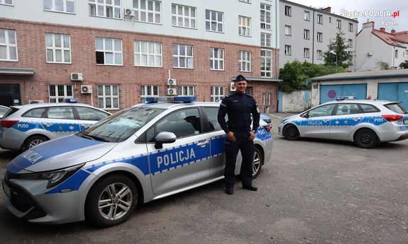 Policjant stoi przy radiowozie