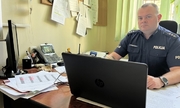 umundurowany policjant siedzi przy biurku