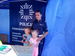 Policjantka pozuje do zdjęcia z dwojgiem dzieci.