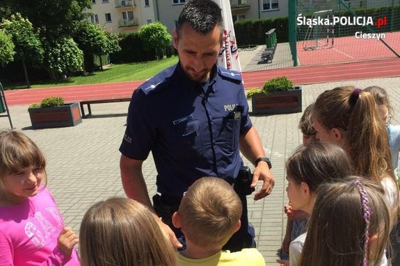 Policjant rozmawia z grupą dzieci.