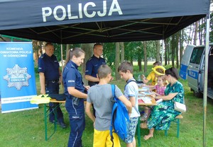 Policjanci z grupą dzieci w namiocie profilaktycznym.