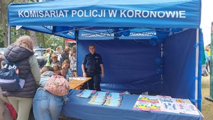 Policjantka w namiocie profilaktycznym z uczestnikami imprezy.