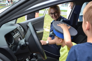 Policjantka z dzieckiem siedzą w radiowozie.