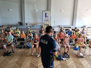 Policjant rozmawiający z grupą dzieci.