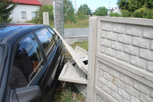 bok czarnego samochodu i leżące na nim elementy betonowego ogrodzenia