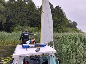 policjant na łodzi policyjnej blisko zarośli