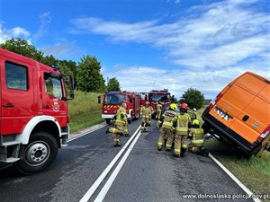 bus w rowie, grupa strażaków wyciągająca bus z rowu, w tle i z boku zdjęcia wozy strażackie