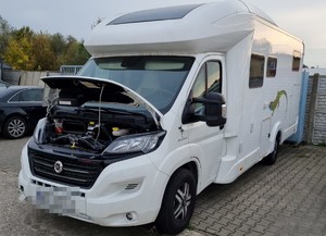 camper z otwartą maską na parkingu