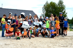policjanci pozują z dziećmi na plaży