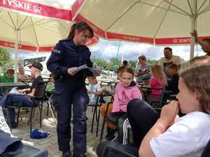 policjantka rozdaje broszury o bezpieczeństwie